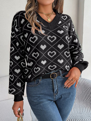 Black acrylic V-neck sweater with allover white heart jacquard pattern and ribbed cuffs.