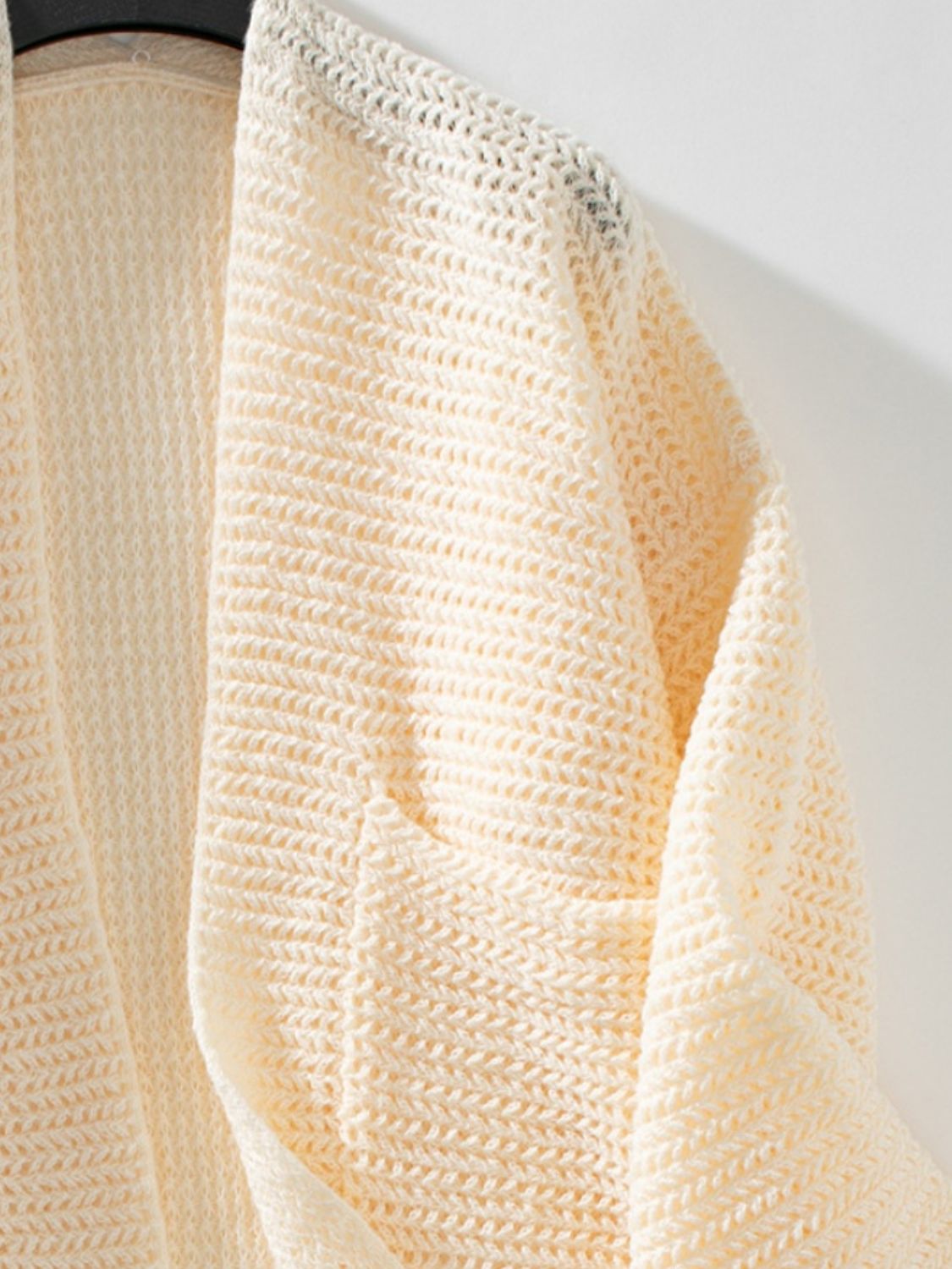 Cream chunky knit open front cardigan with a textured weave and open crochet detail at the neckline.