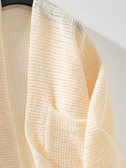 Cream chunky knit open front cardigan with a textured weave and open crochet detail at the neckline.