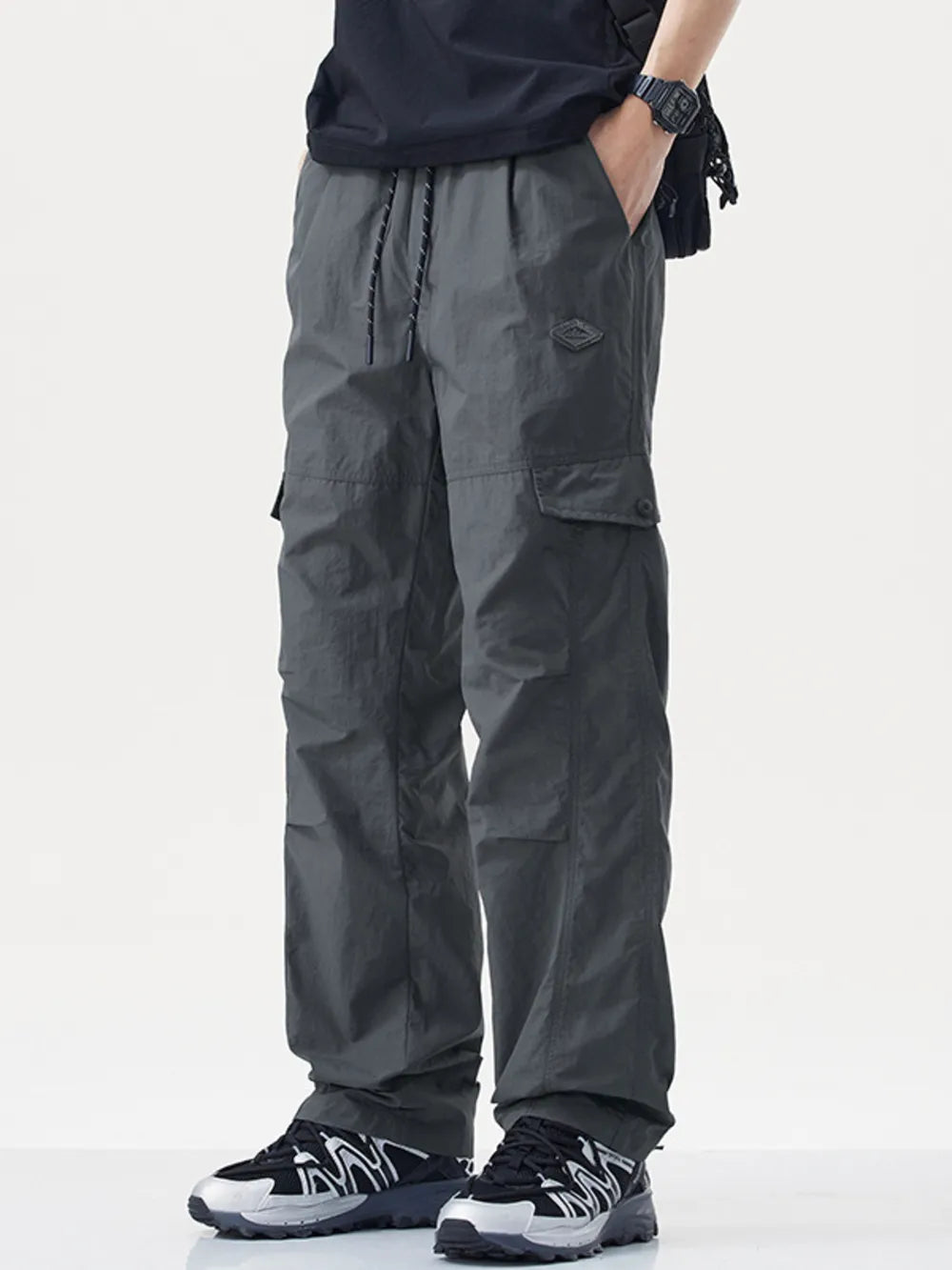 Relaxed fit gray cargo sweatpants with drawstring and button closure pockets.