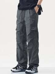 Relaxed fit gray cargo sweatpants with drawstring and button closure pockets.
