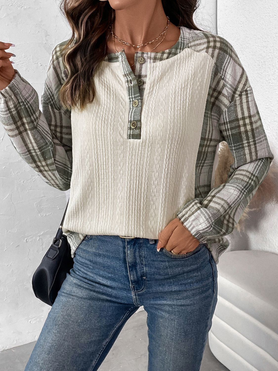 Cream textured henley top with plaid raglan sleeves and button detail.