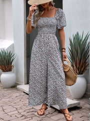 Floral smocked bodice wide leg jumpsuit in light blue with puff sleeves and square neckline.