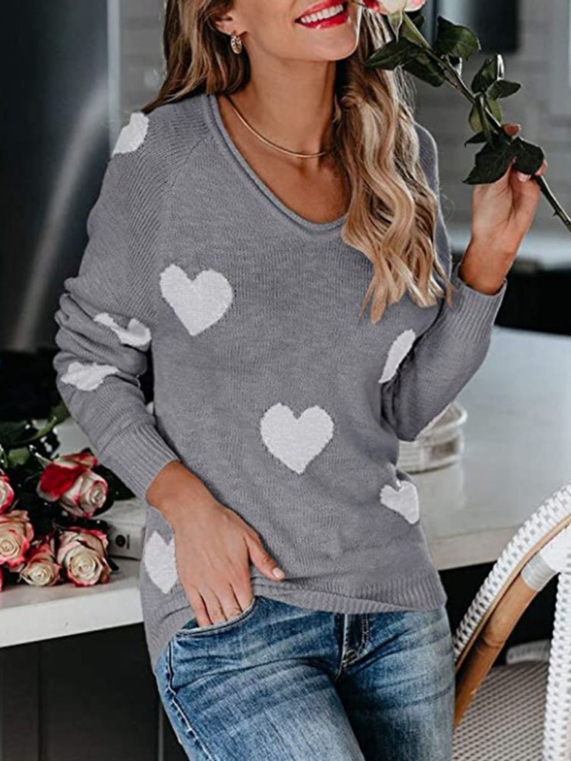 Gray raglan knit sweater with white heart motif, v-neck, long sleeves.
