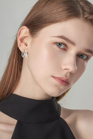 Silver sculptural hoop earrings with diamond accents.