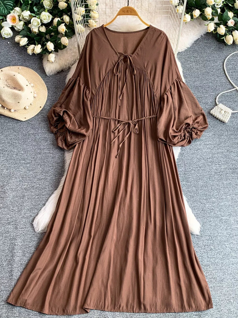 Brown bohemian maxi dress with balloon sleeves, v-neck, and tie waist.