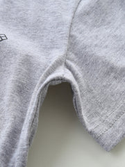 Toddler grey cotton t-shirt detail showing seams and a partial graphic.