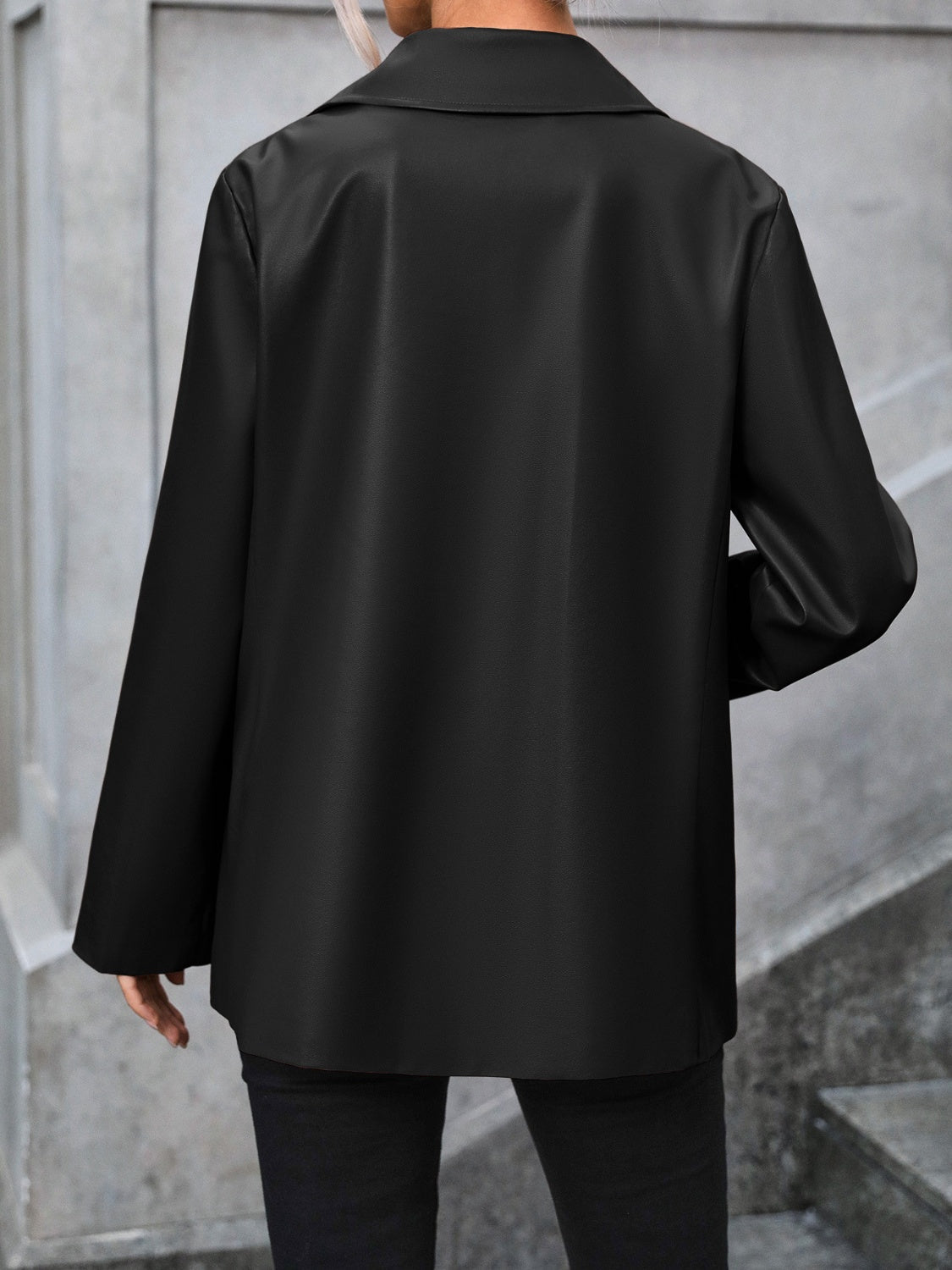 Black faux leather tailored blazer with a classic collar and long sleeves.