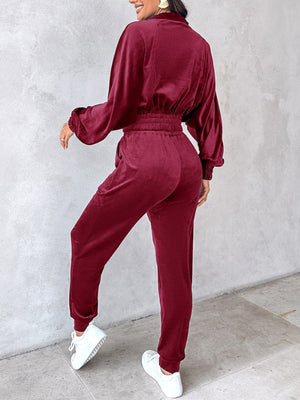 Burgundy velvet crop tracksuit with cinched waist and zipper detail.