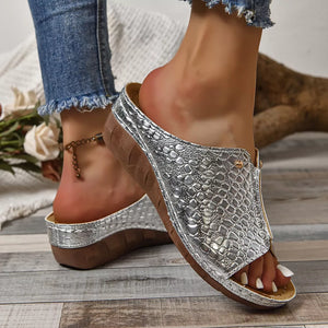 Silver glossy crocodile-embossed wedge sandals with peep toe and comfortable sole.