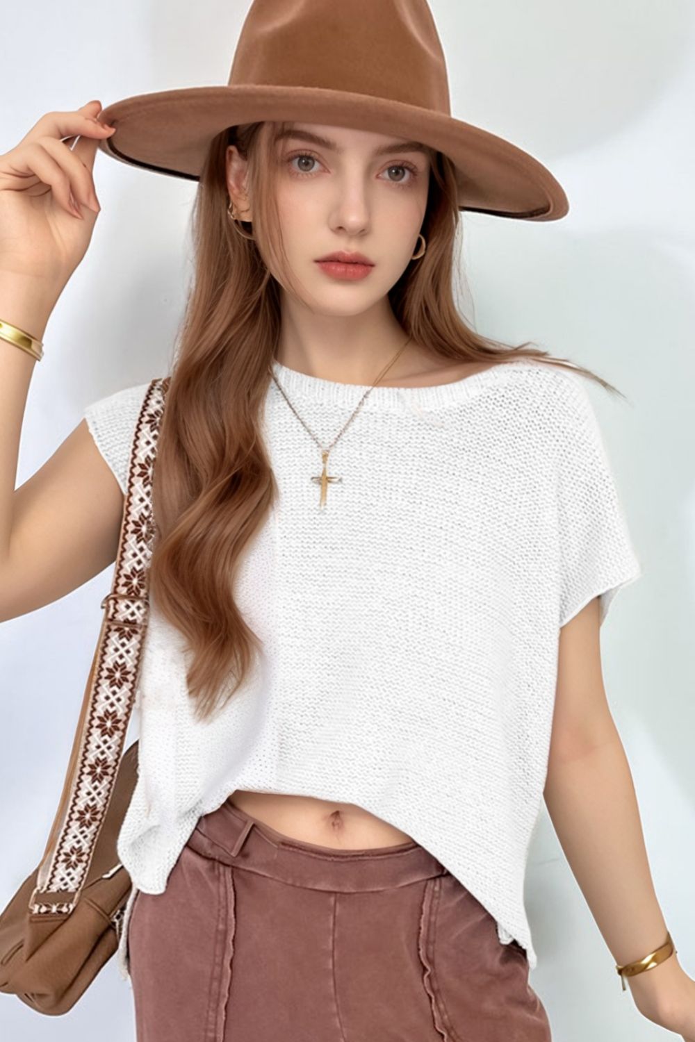 White boxy knit crop top with short sleeves and a boat neck.