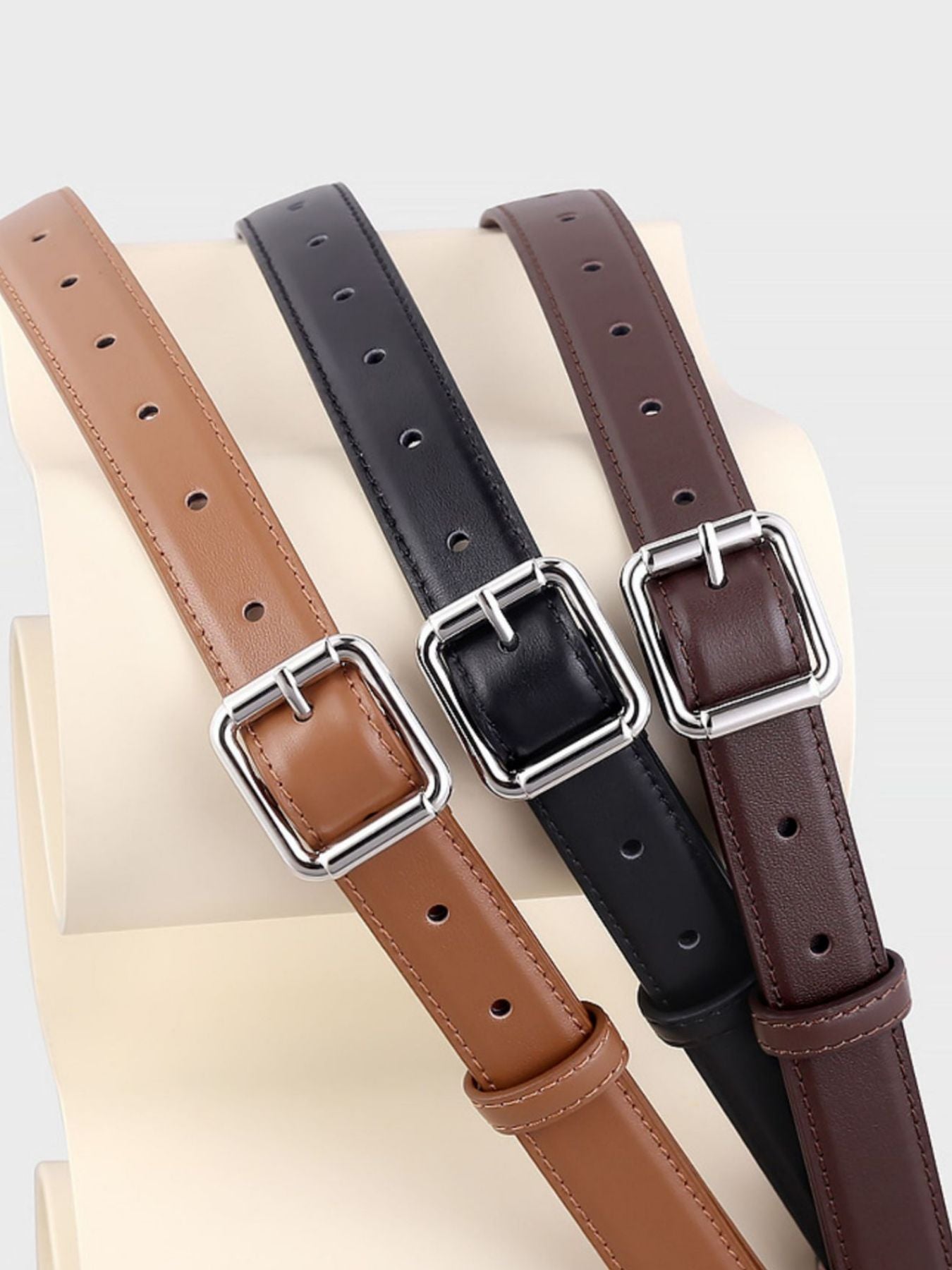 Premium cowhide leather belts in brown, black, and caramel with square silver buckles.