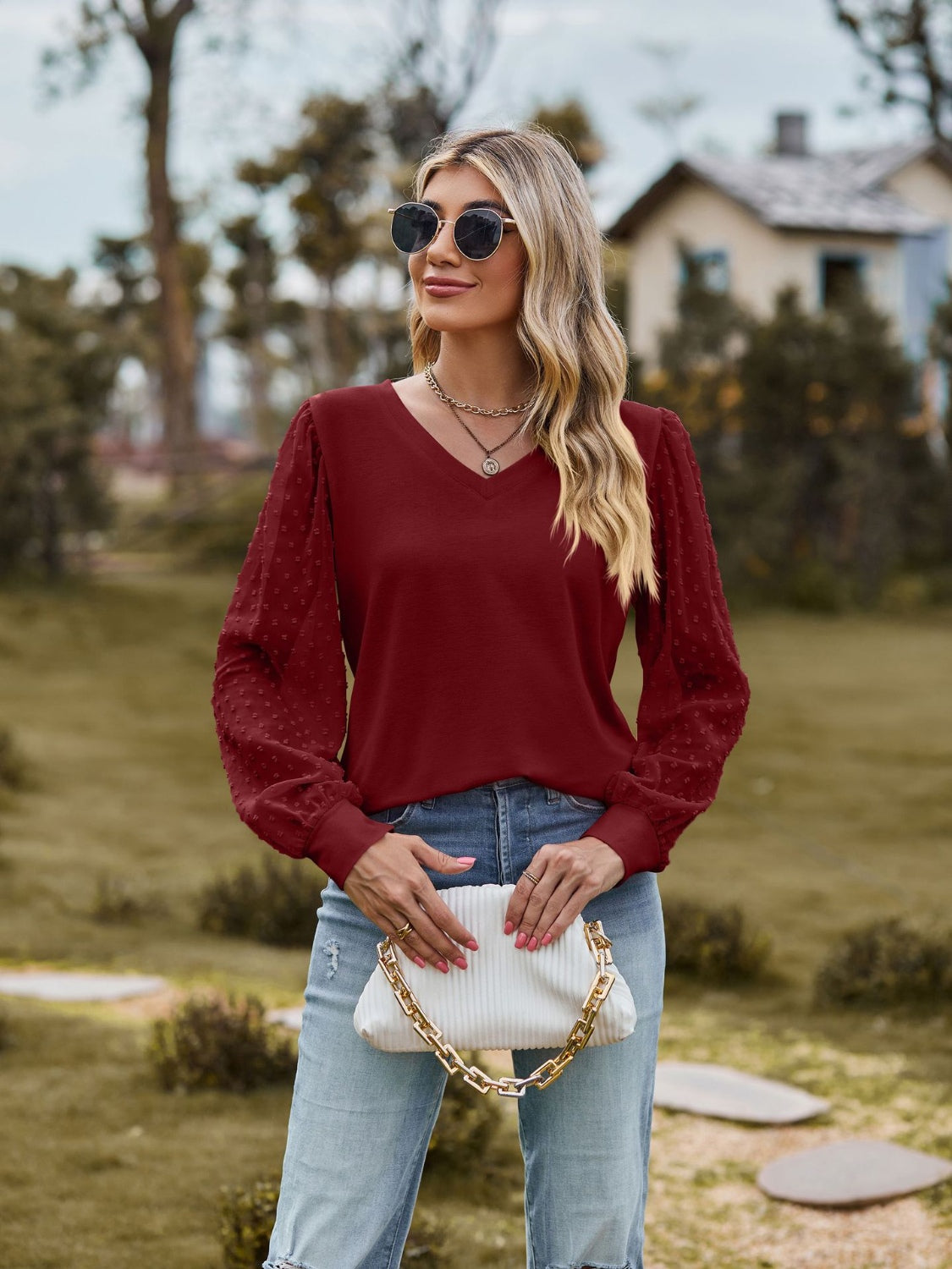 Burgundy V-neck blouse with Swiss dot textured sleeves and long sleeves.