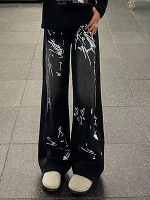 Black wide-leg jeans with white graffiti print and hearts.