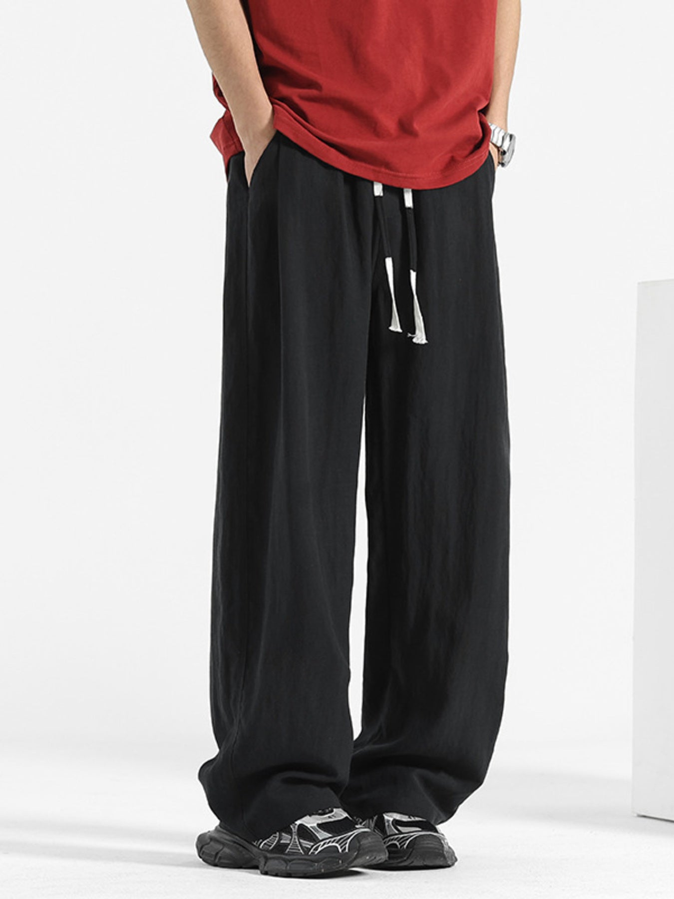 Men's black loose fit drawstring pants with a relaxed cut.