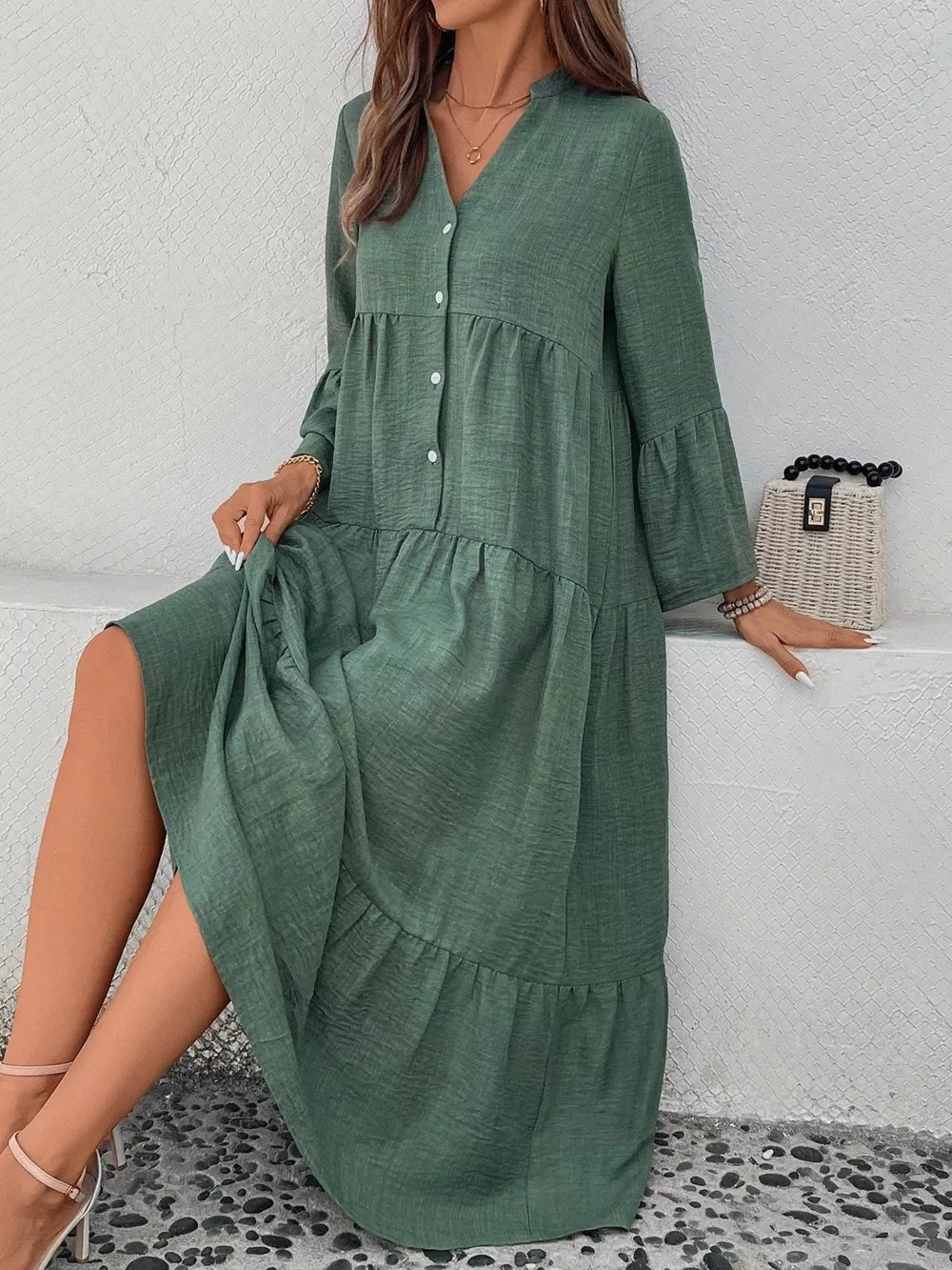 Green tiered ruffle hem v-neck dress with button front and bell sleeves.