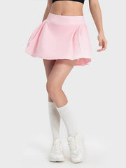 Pleated performance mini skirt in blush pink with a flared cut.