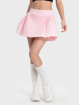 Pleated performance mini skirt in blush pink with a flared cut.