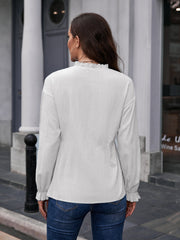 White textured ruffle collar peplum blouse with long sleeves and ruffled cuffs.