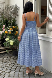 Blue gingham midi dress with smocked bodice and spaghetti straps, A-line skirt.