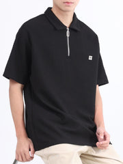 Black textured polo shirt with short sleeves and a zipper detail