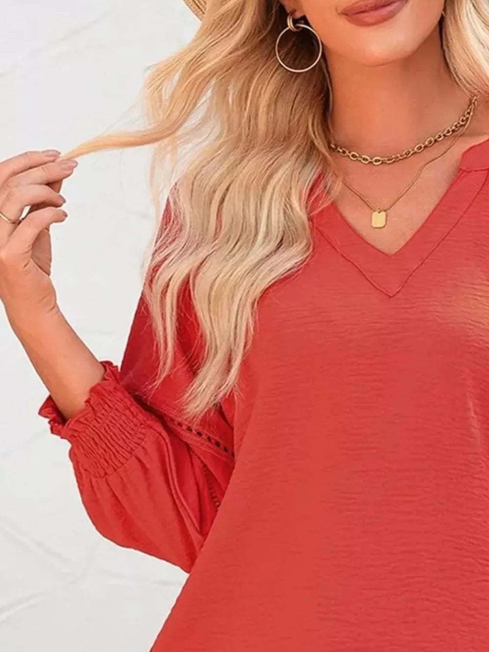 Red polyester blouse with smocked cuffs and V-neck