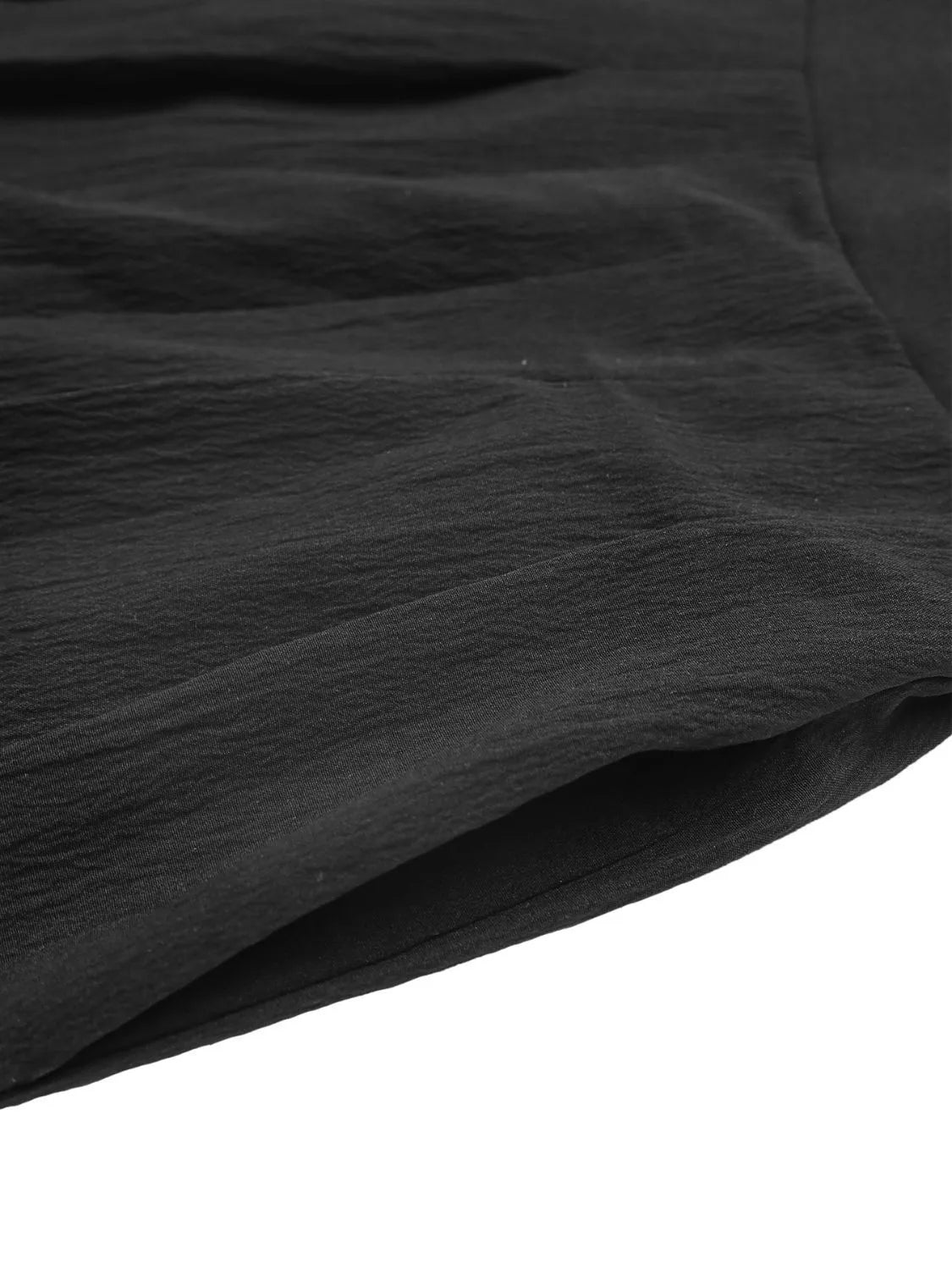 Black pleated shorts with textured fabric and pocket detail