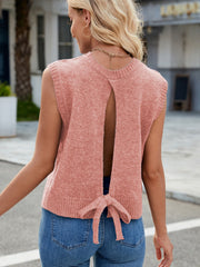 Open-back knit vest in pale blush with a tie bow detail at the hem.