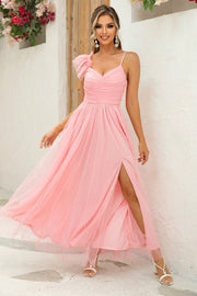 Blush pink tulle gown with asymmetrical ruffle detail, sweetheart neckline, spaghetti straps, and high slit.