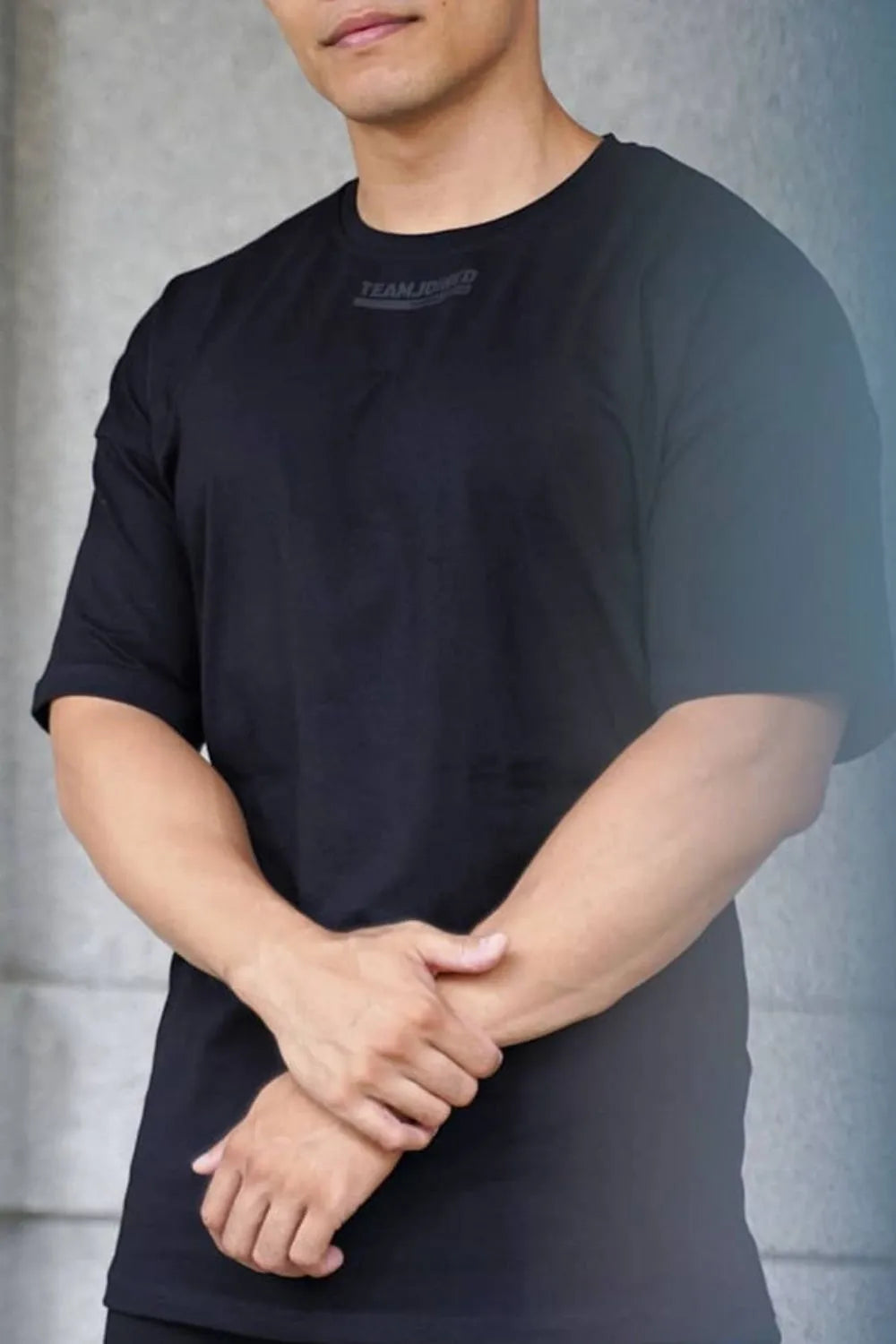 Black oversized t-shirt with subtle tonal logo detail on chest