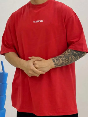 Red oversized t-shirt with white VETEMENTS logo on chest.