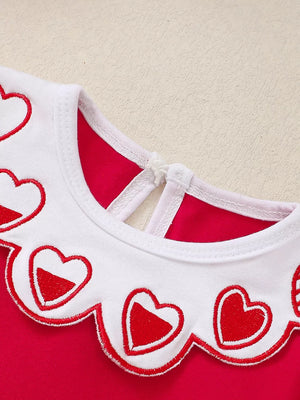 Red baby dress with white scalloped collar embroidered with red hearts.