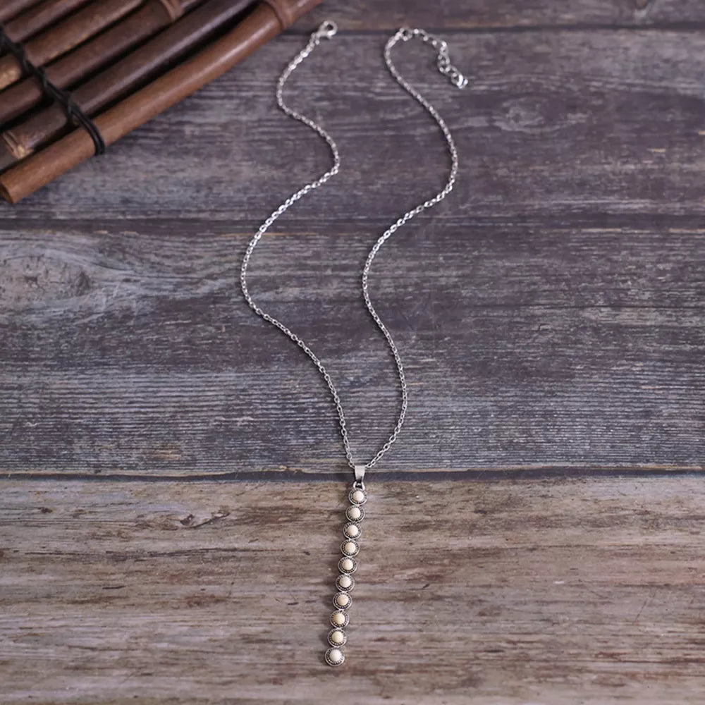 Delicate white beaded pendant necklace with silver chain.