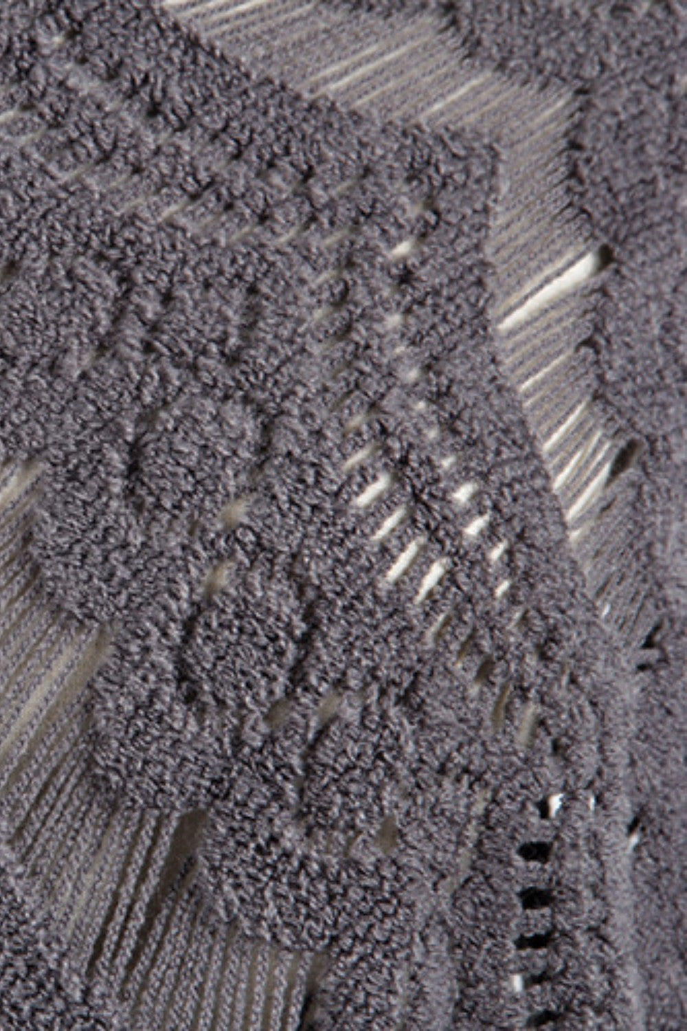Dark gray acrylic crochet poncho with open knit pattern and fringe detail.