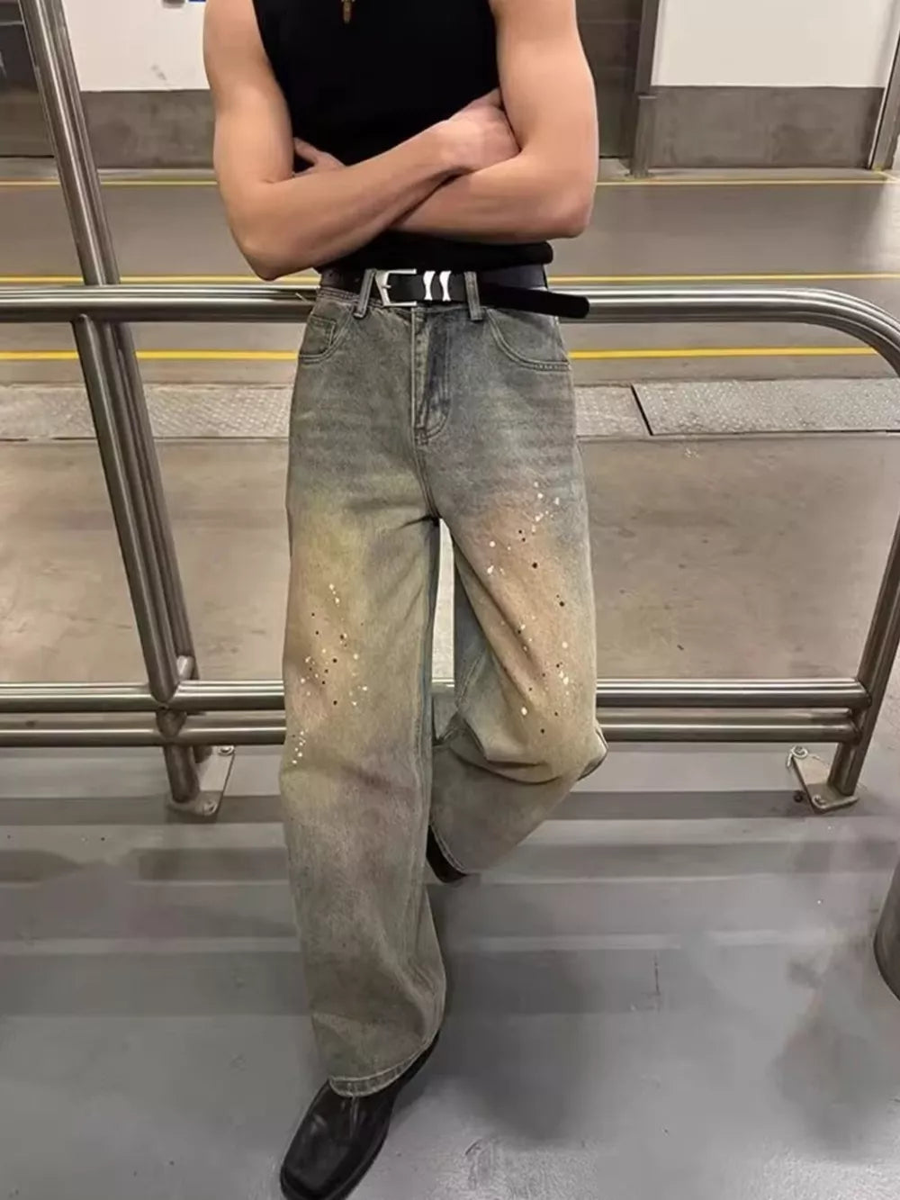Vintage wash wide-leg jeans with distressed details and paint splatters.