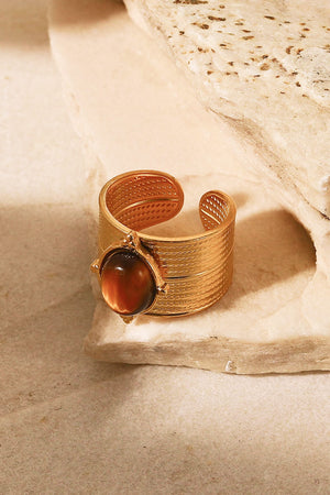 Textured tiger's eye cuff ring in gold with brown stone detail.