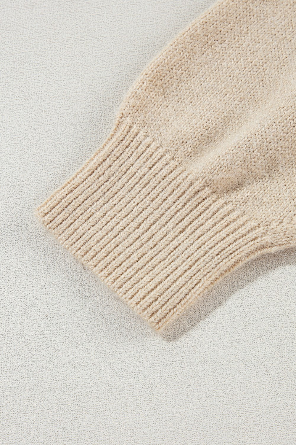 Tan knit sweater sleeve with ribbed cuff detail, acrylic fabric.