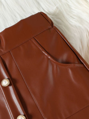 Brown faux leather skirt with decorative pearl buttons and pocket detail.