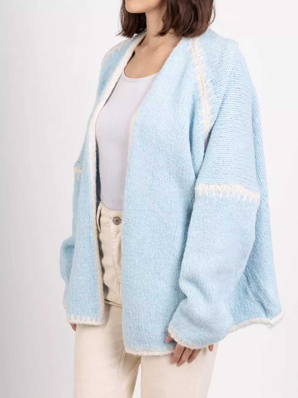 Light blue oversized cardigan with contrast trim and textured knit.