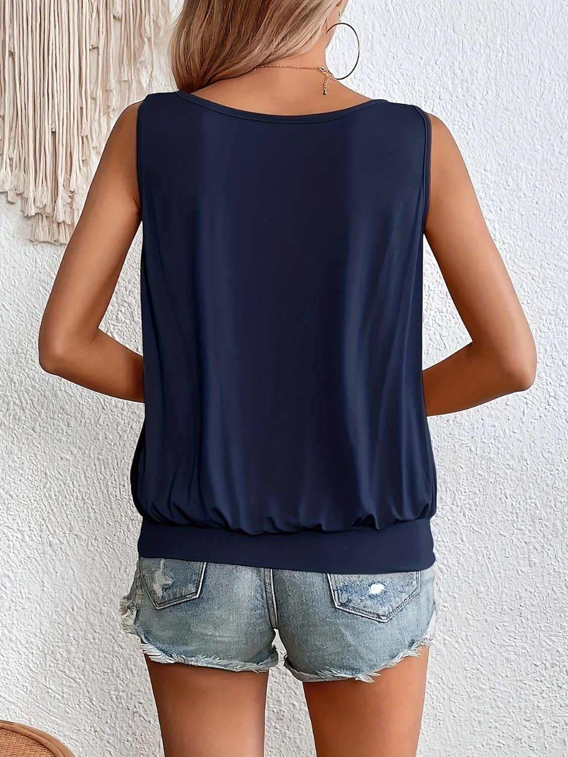 Gathered front tank top in dark navy with a cinched hem, worn with denim shorts.
