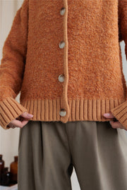 Textured bouclé collar cardigan in tangerine with button front and ribbed trim.