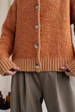 Textured bouclé collar cardigan in tangerine with button front and ribbed trim.