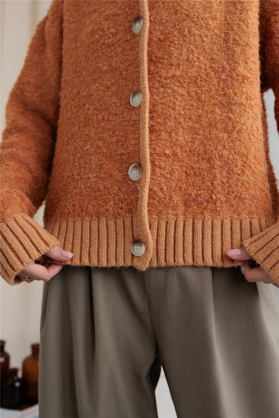 Textured bouclé collar cardigan in tangerine with button front and ribbed trim.
