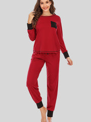 Red loungewear set with black trim on cuffs and pocket, drawstring waist.