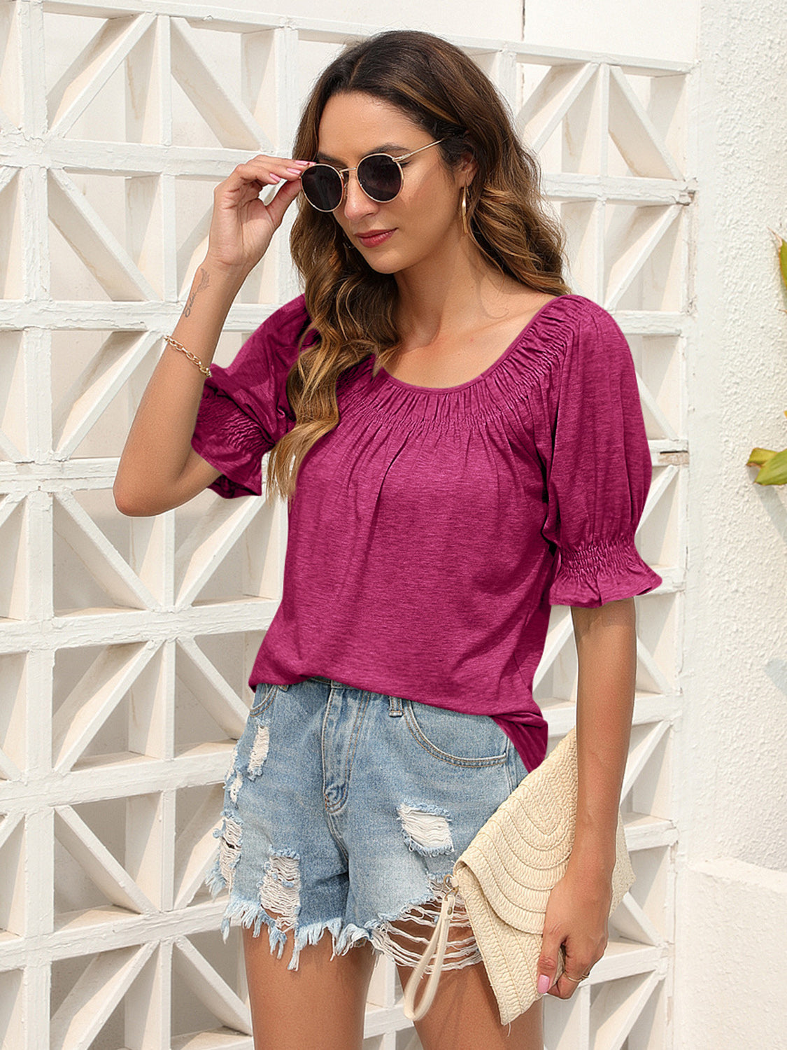 Off-shoulder ruffled sleeve top in hot pink with gathered neckline and ruched cuffs.