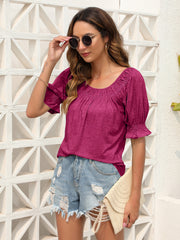 Off-shoulder ruffled sleeve top in hot pink with gathered neckline and ruched cuffs.