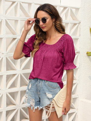 Off-shoulder ruffled sleeve top in hot pink with gathered neckline and ruched cuffs.