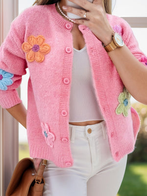 Pink textured knit button-front cardigan with embroidered floral appliques.