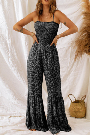 Black floral print jumpsuit with smocked bodice and flared ruffle legs.