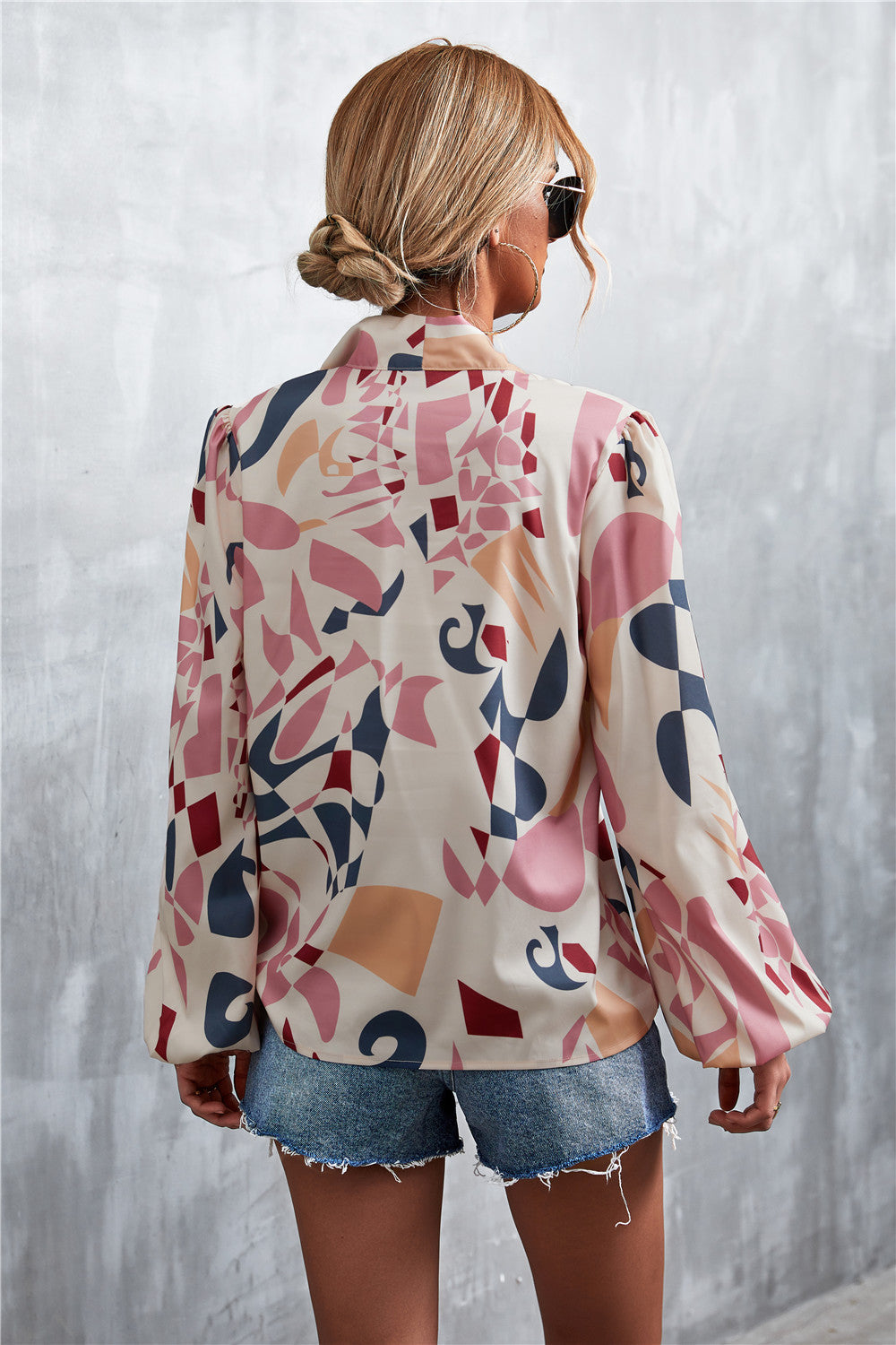 Women's abstract print blouse with balloon sleeves and a pussy bow neckline, in a multi-color pattern.